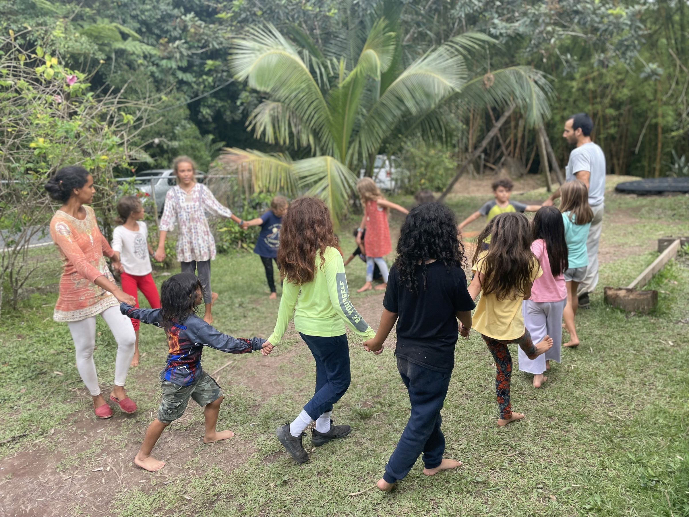 Niñas y niños de Camposofía bailando en círculo entre las montañas de Utuado